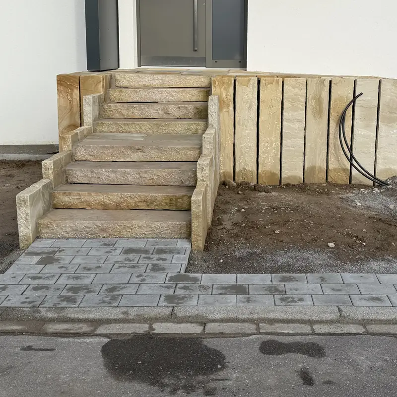 Eingangstreppe aus Sandstein-Blockstufen mit angesetzter Stützwand