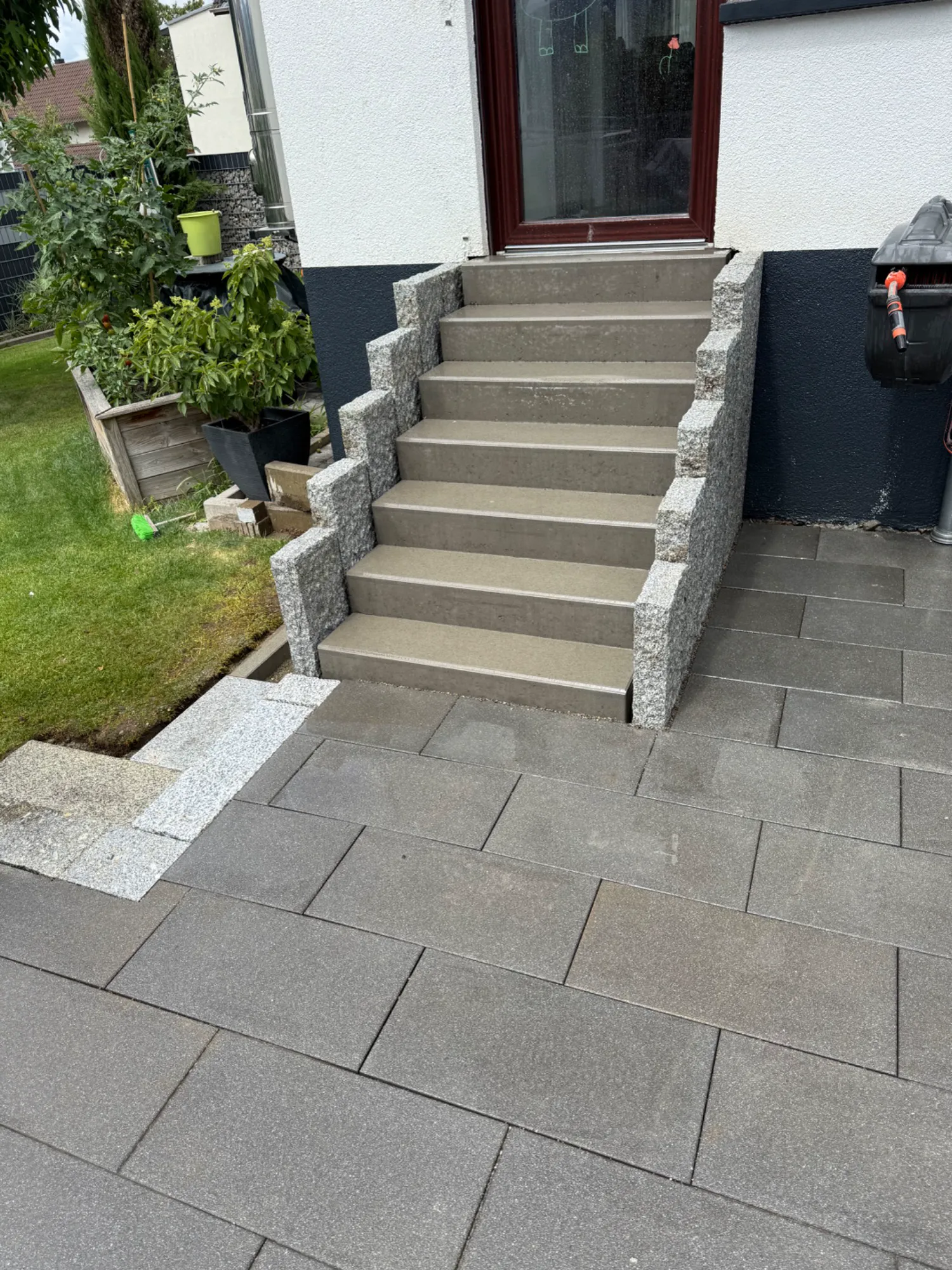 Außentreppe aus hellen Blockstufen mit Granit-Mauerelementen